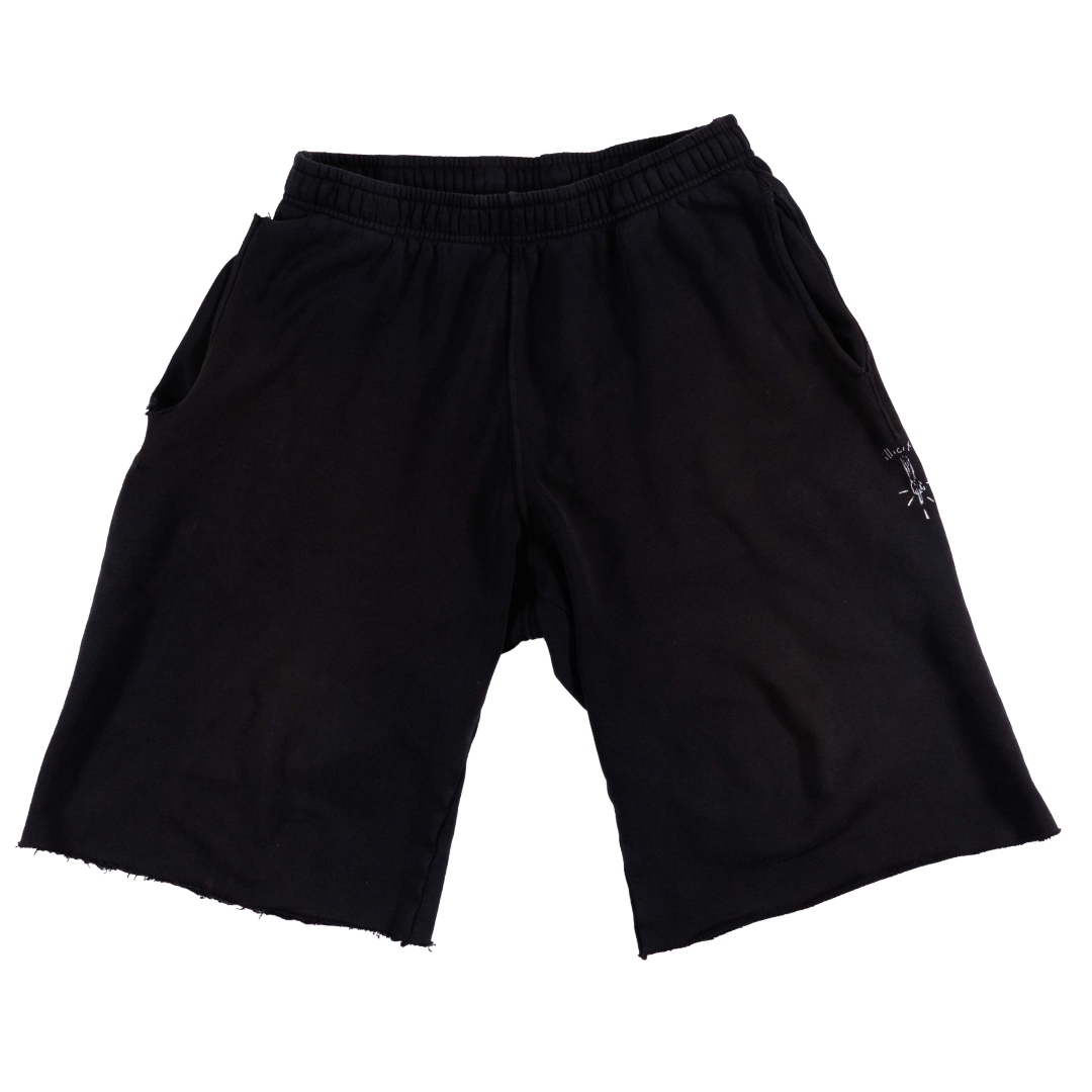 Black sweat shorts with a raw hem and a small white embroidered logo on the left leg, shown against a plain white background.